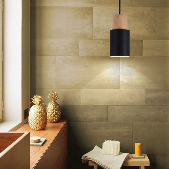 Moderne schwarze Pendelleuchte aus Holz in stilvollem Wohnzimmer mit goldenen Ananas-Dekorationen.