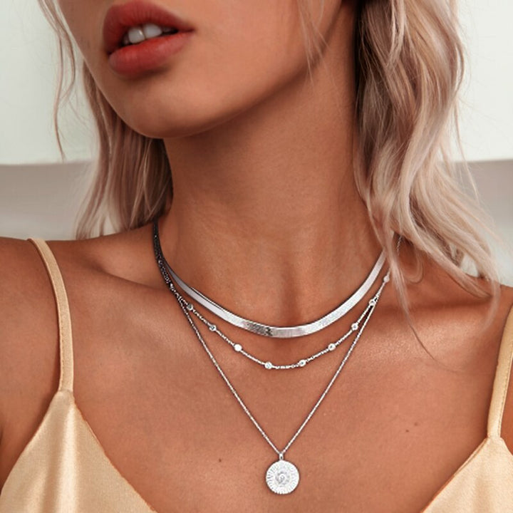 Frau mit drei silbernen Halsketten, Anhänger, modisch, eleganter Schmuck, Nahaufnahme.