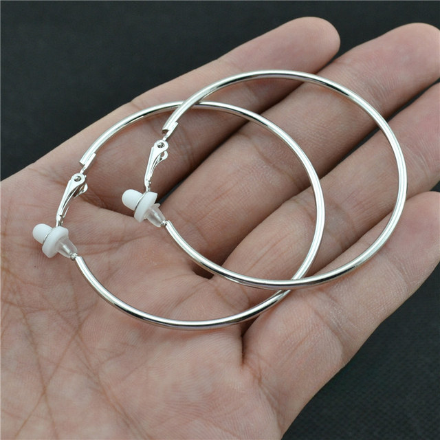 Silberne Creolen Ohrringe, 2,5 cm, auf Handfläche, Schmuck, modisch, elegant, Damenaccessoire.