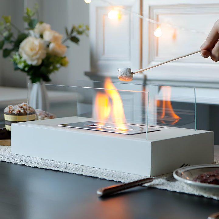Moderner Tischkamin aus Glas und Metall, weiß, mit brennender Flamme, ideal für Innenräume.