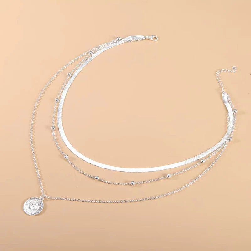 Silberne Halskette mit Sonnenanhänger, mehrlagig, Damenmode, Schmuckaccessoire, elegant.