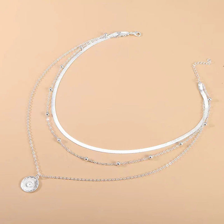 Silberne Halskette mit Sonnenanhänger, mehrlagig, Damenmode, Schmuckaccessoire, elegant.