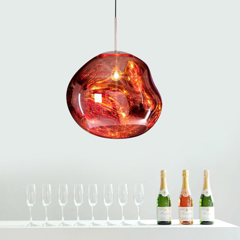 Moderne rote Glaspendelleuchte über Tisch mit Sektflaschen und Gläsern.