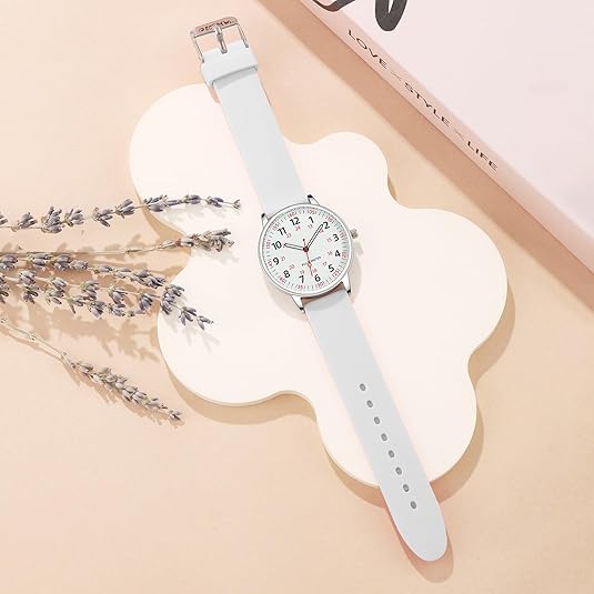 Silberne Armbanduhr mit weißem Zifferblatt und grauem Lederarmband auf beigem Hintergrund.