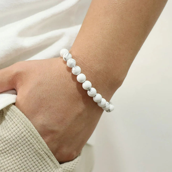 Weiße Howlith-Armband, elastisch, unisex, auf Handgelenk getragen, modisches Accessoire.