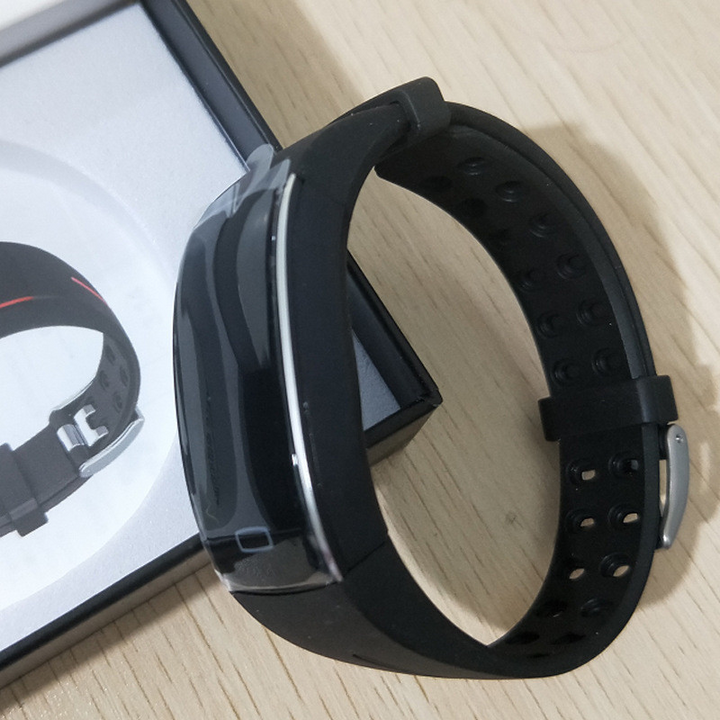Schwarze Smartwatch mit Silikonarmband auf Holztisch, Fitness-Tracker, moderne Technologie.