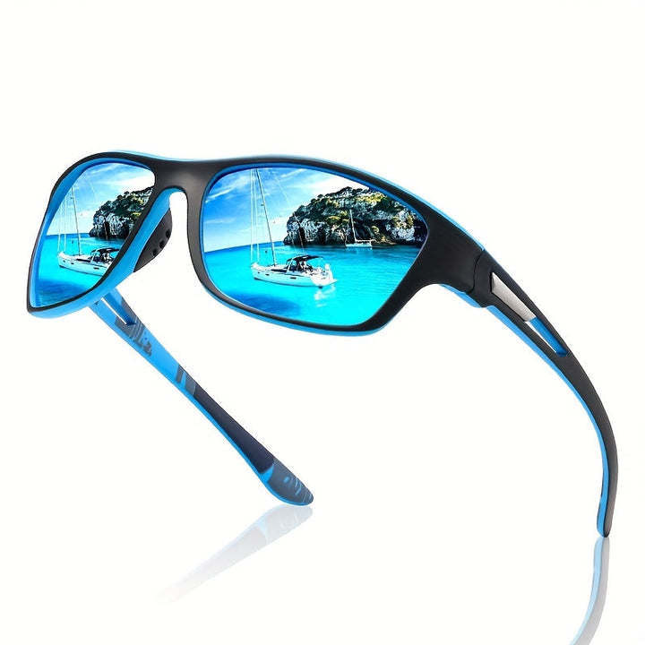 Blaue Sonnenbrille mit polarisierten Gläsern, spiegelt Segelboot und tropische Landschaft.