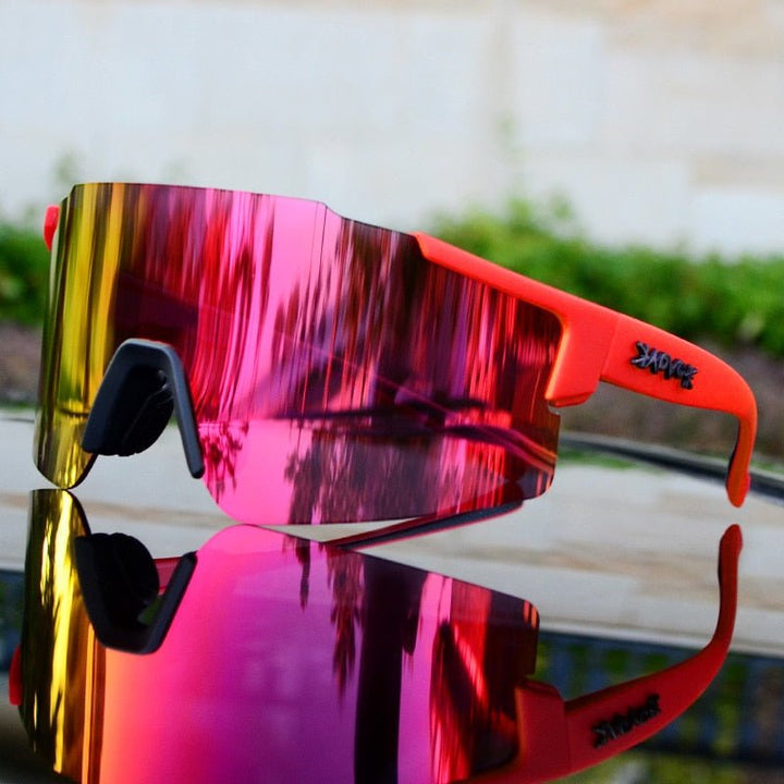 Rote Sportsonnenbrille mit verspiegelten Gläsern, modisches Design, ideal für Outdoor-Aktivitäten.