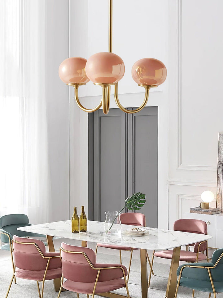 Rosa Kronleuchter aus Glas und Metall über Marmortisch in modernem Esszimmer.