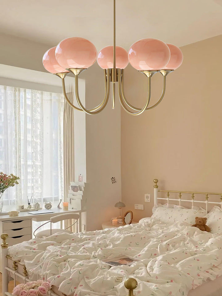 Rosa Kronleuchter im Schlafzimmer, modernes Design, goldene Arme, elegante Beleuchtung.