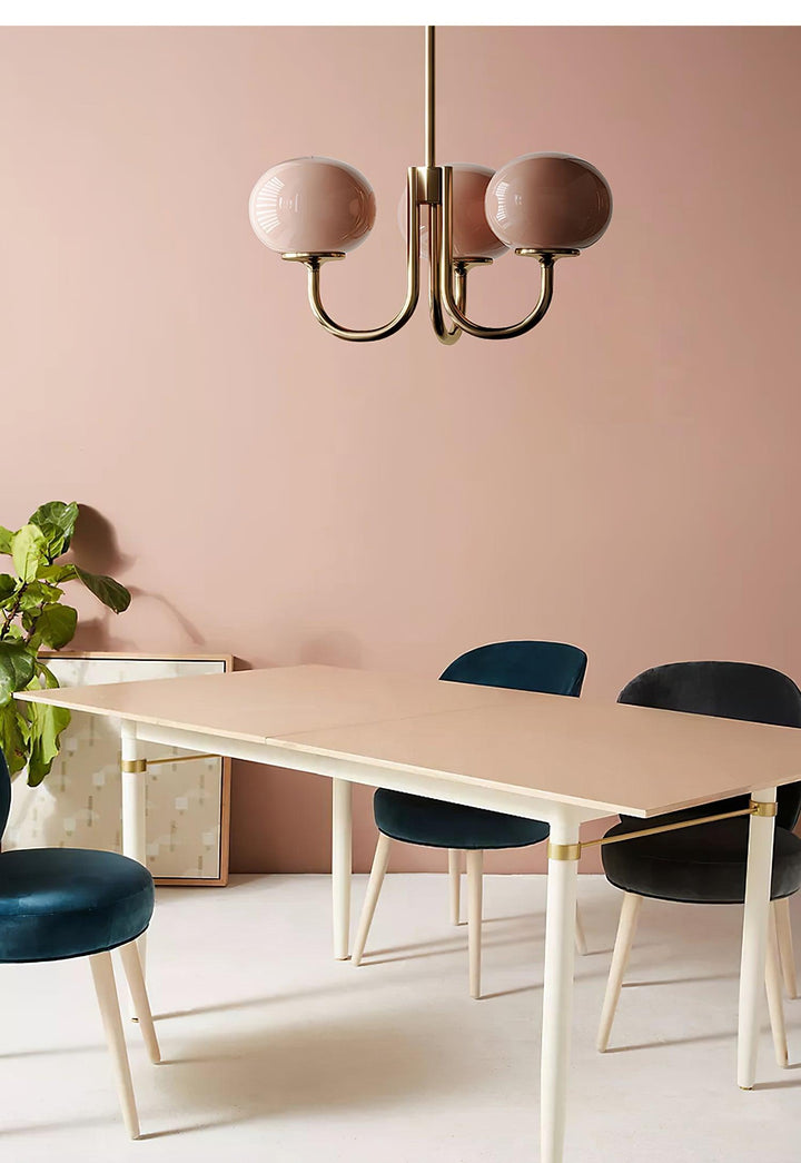 Moderne Kronleuchter mit rosa Glaskugeln über Esstisch, skandinavisches Design, Wohnzimmer.