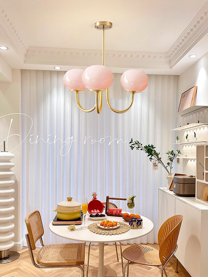 Rosa Kronleuchter im Esszimmer, modernes Design, goldene Akzente, skandinavischer Stil.