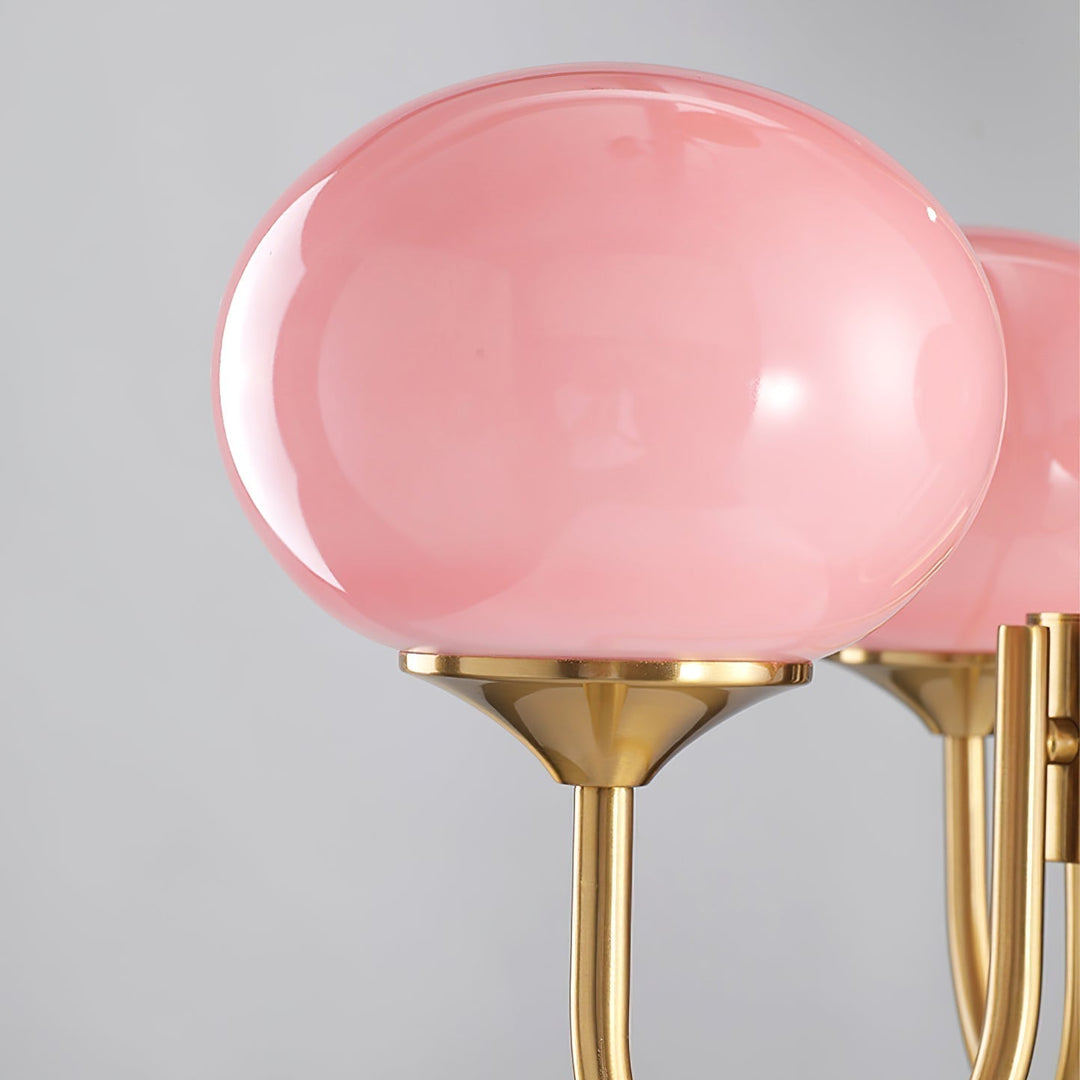 Rosa Glas-Kronleuchter mit goldenen Halterungen, modernes Design, elegante Beleuchtung.