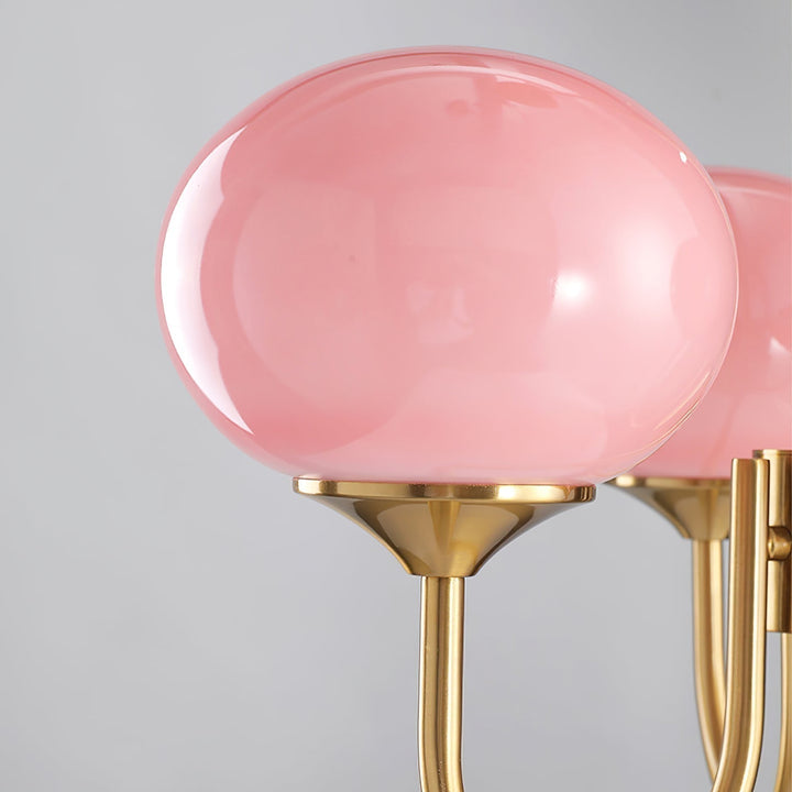 Rosa Glas-Kronleuchter mit goldenen Halterungen, modernes Design, elegante Beleuchtung.