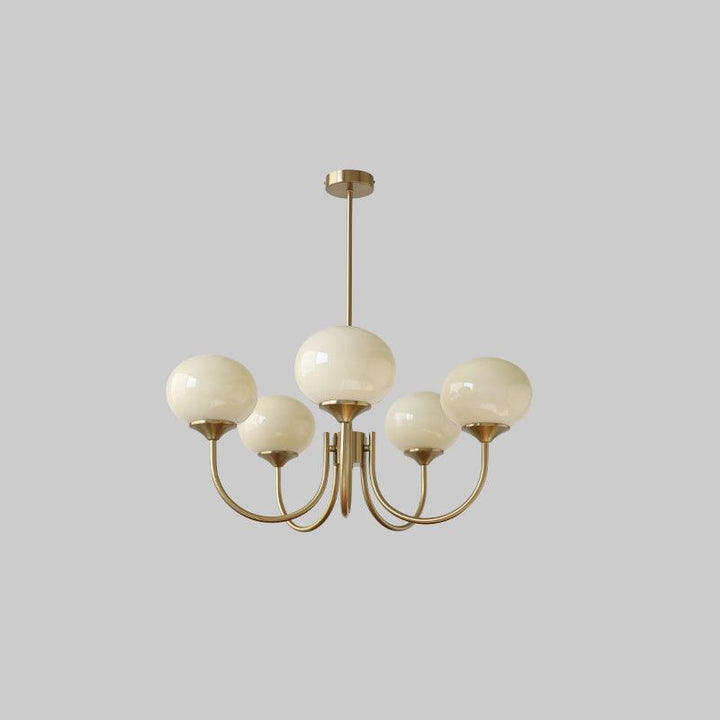 Moderner Kronleuchter mit sechs weißen Glaskugeln, goldene Metallstruktur, elegantes Design.