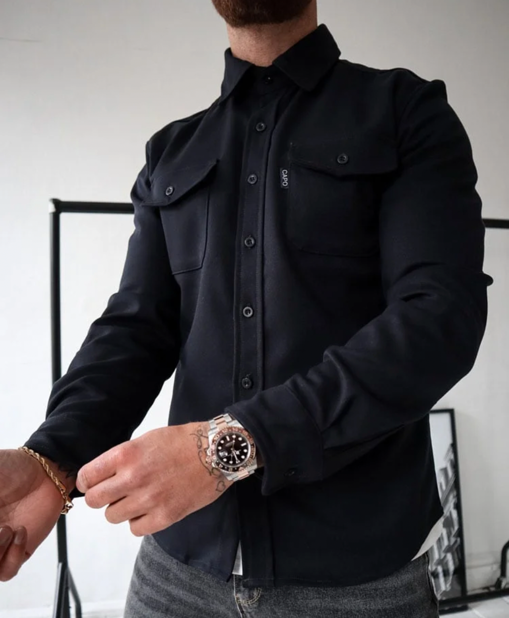 Mann in schwarzem Hemd mit Uhr, stilvolle Herbstmode, langärmlig, Knopfleiste, Freizeitkleidung.