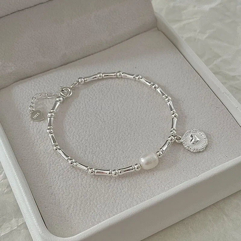 Silberarmband mit Perle und Anhänger in Schmuckschatulle, elegantes Design, Damenaccessoire.