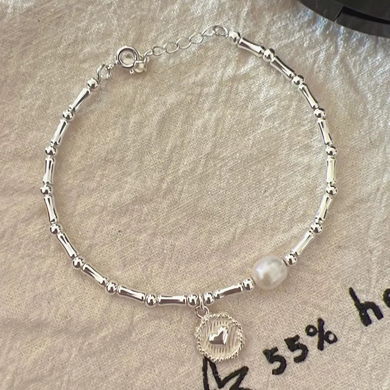 Silberarmband mit Perle und Anhänger, Damen-Schmuck, elegantes Design, Geschenkidee.