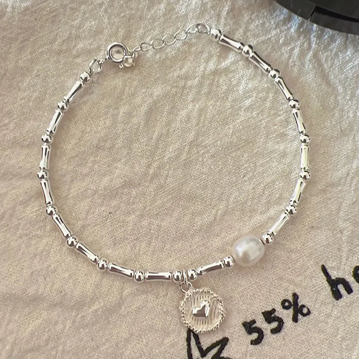 Silberarmband mit Perle und Anhänger, Damen-Schmuck, elegantes Design, Geschenkidee.