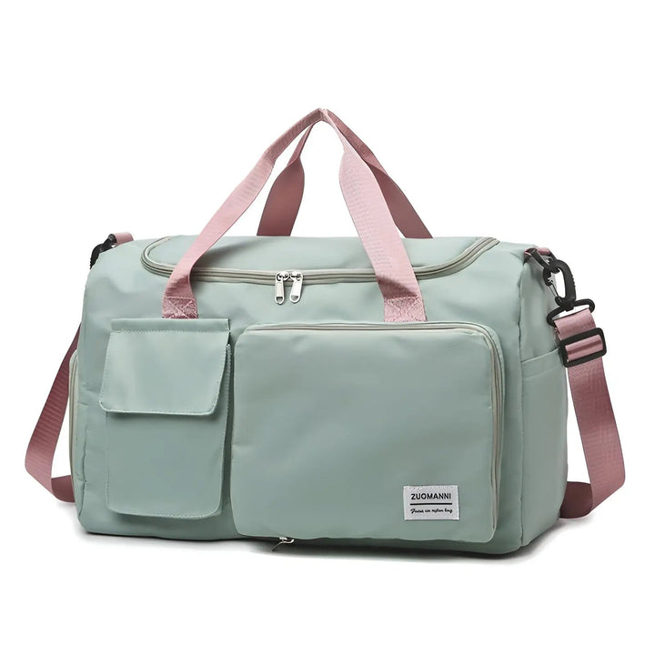 Mintgrüne Reisetasche mit rosa Trägern, Fronttaschen, Reißverschluss, ideal für Reisen.