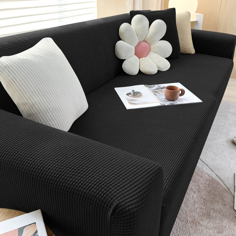 Schwarzes Sofa mit weißen Kissen und Blumenmotiv, modernes Wohnzimmer, gemütliche Einrichtung.