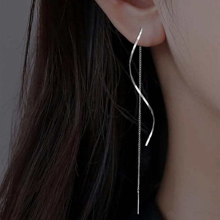 Silberne, lange Ohrringe, geschwungenes Design, modischer Schmuck für Damen.