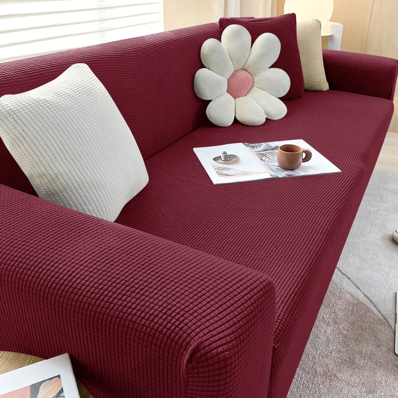 Roter Sofaüberwurf, gerippt, mit Kissen und Zeitschriften, modernes Wohnzimmerdekor.