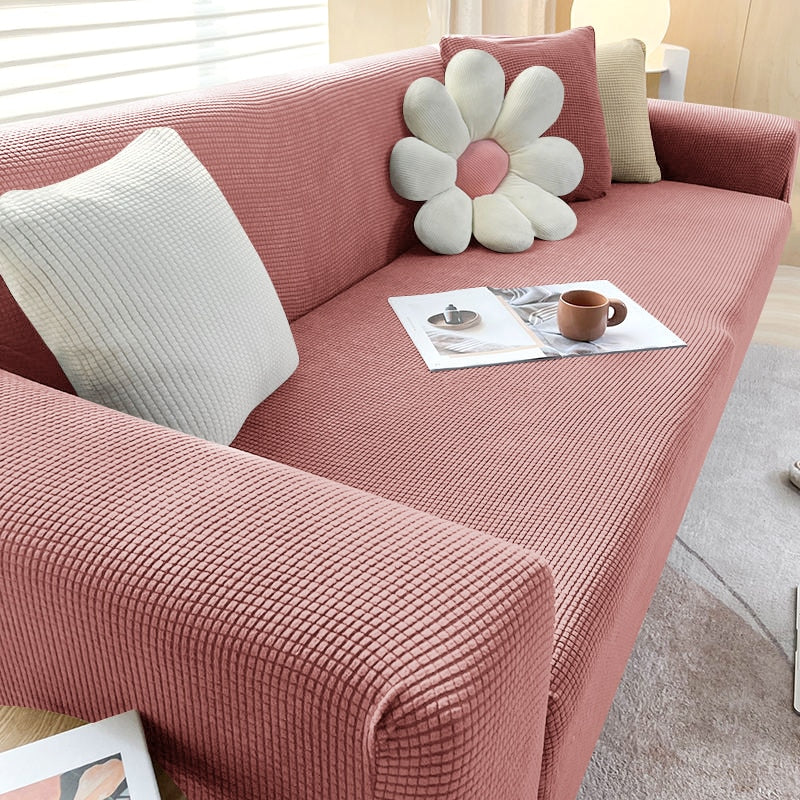 Rosa Sofa mit strukturiertem Stoff, dekoriert mit Kissen und Zeitschriften, modernes Wohnzimmer.