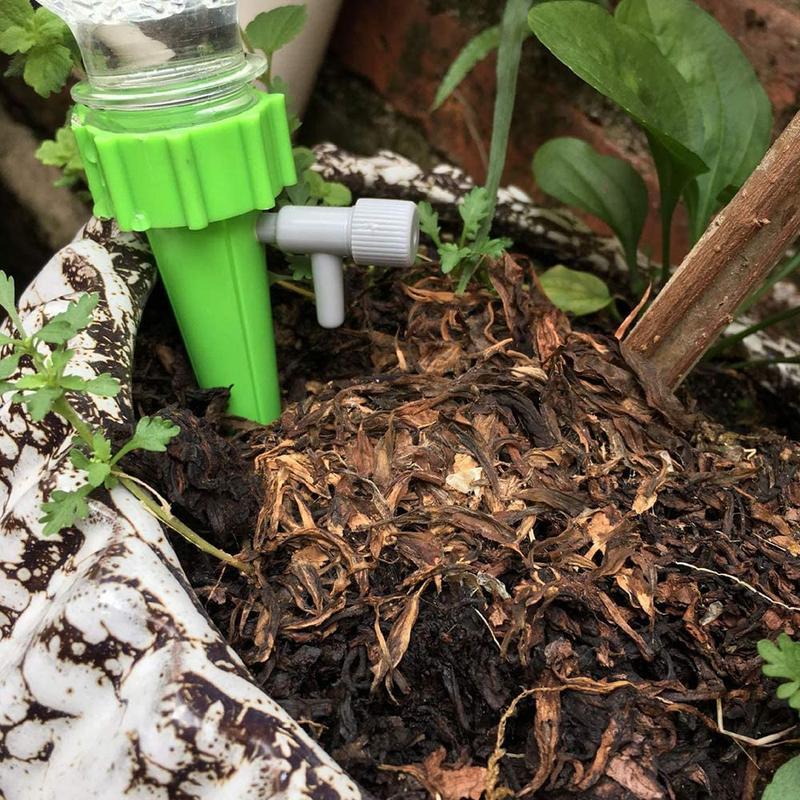 Automatische Pflanzenbewässerung, grünes Kunststoffsystem mit Flaschenanschluss, Urlaubssicherheit für Gartenpflanzen.