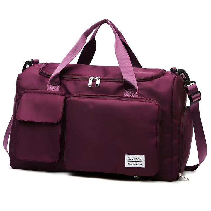 Lila Reisetasche aus Nylon mit mehreren Fächern und verstellbarem Schultergurt.
