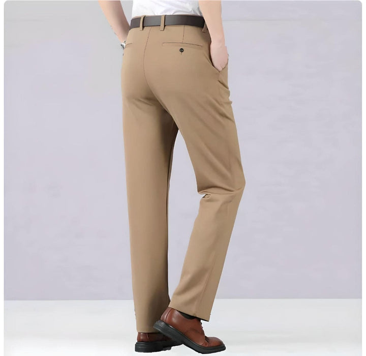 Beige Herren-Chinohose, Rückansicht, aus Baumwolle, elegant, mit braunen Lederschuhen.