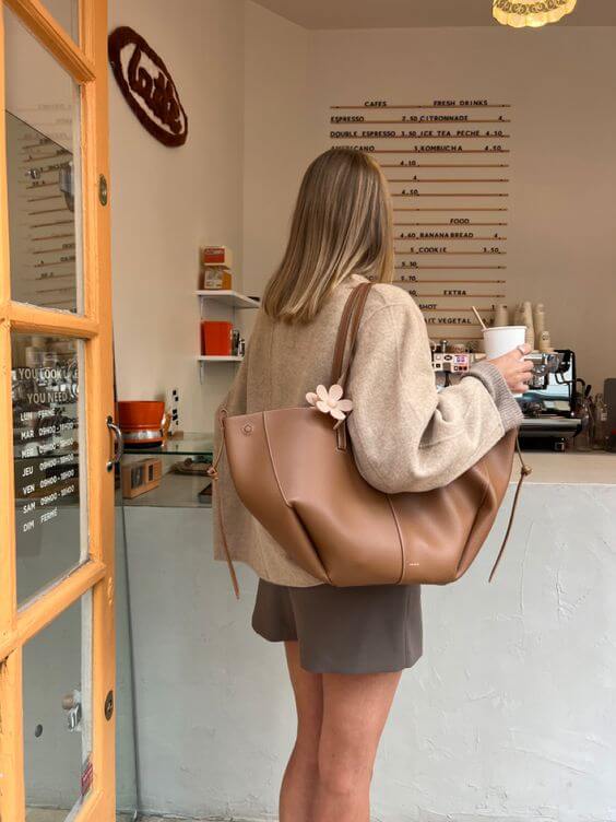"Braune Leder Tote Bag auf Marmortisch, stilvolle Damenhandtasche, geräumig und vintage, ideal für Büro und Shopping."