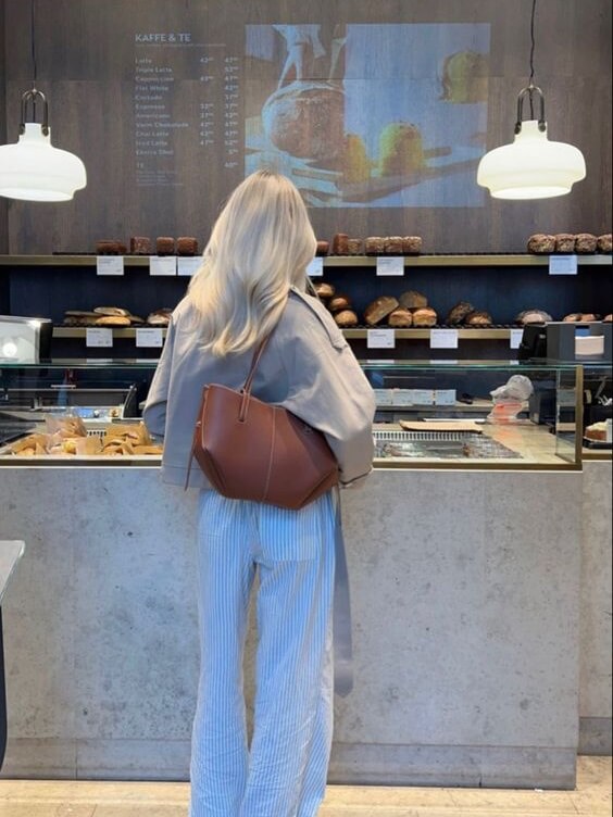 "Braune Leder Tote Bag auf Marmortisch, stilvolle Damenhandtasche, geräumig und vintage, ideal für Büro und Shopping."