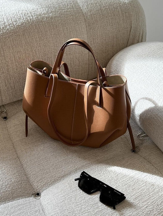 "Braune Leder Tote Bag auf Marmortisch, stilvolle Damenhandtasche, geräumig und vintage, ideal für Büro und Shopping."