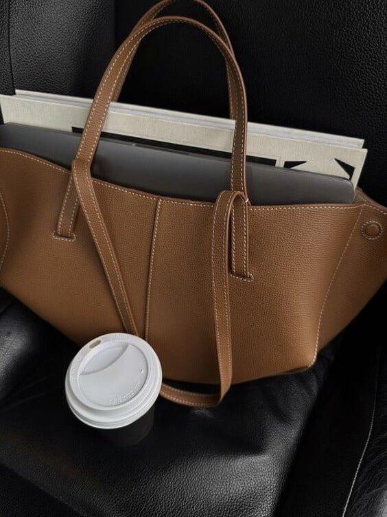 "Braune Leder Tote Bag auf Marmortisch, stilvolle Damenhandtasche, geräumig und vintage, ideal für Büro und Shopping."