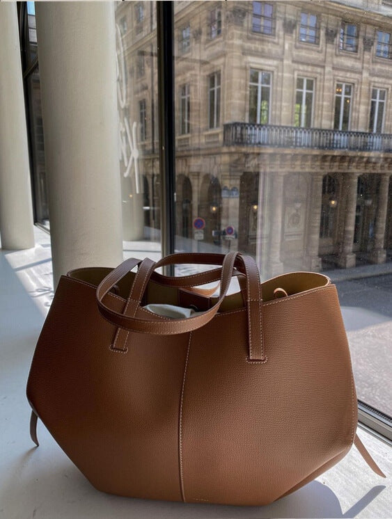 "Braune Leder Tote Bag auf Marmortisch, stilvolle Damenhandtasche, geräumig und vintage, ideal für Büro und Shopping."