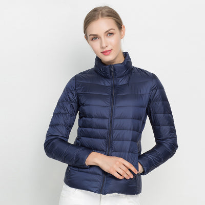 Frau in dunkelblauer Daunenjacke, Stehkragen, Reißverschluss, Wintermode, isoliert.
