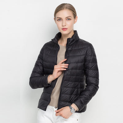 Frau in schwarzer Daunenjacke, Stehkragen, modisch, warm, Winterbekleidung, Damenmode.