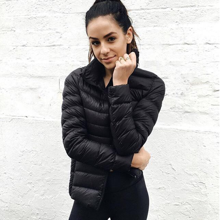 Frau in schwarzer Daunenjacke, sportlich, modisch, Winterbekleidung, Outdoor, warm, elegant.