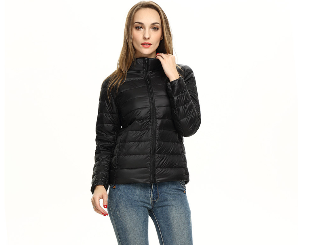 Frau trägt schwarze Daunenjacke, Stehkragen, Reißverschluss, modisch, warm, Winterbekleidung.