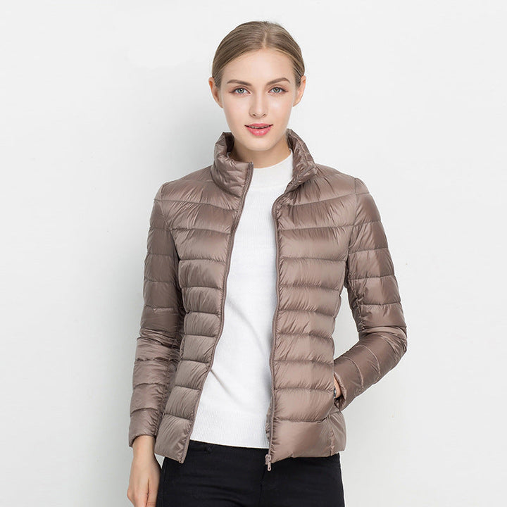 Frau in brauner Daunenjacke, Stehkragen, Reißverschluss, modisch, warm, Winterbekleidung.