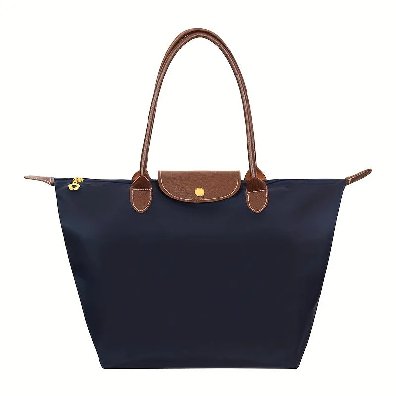 Dunkelblaue Damenhandtasche aus Nylon mit braunen Ledergriffen und Klappe.