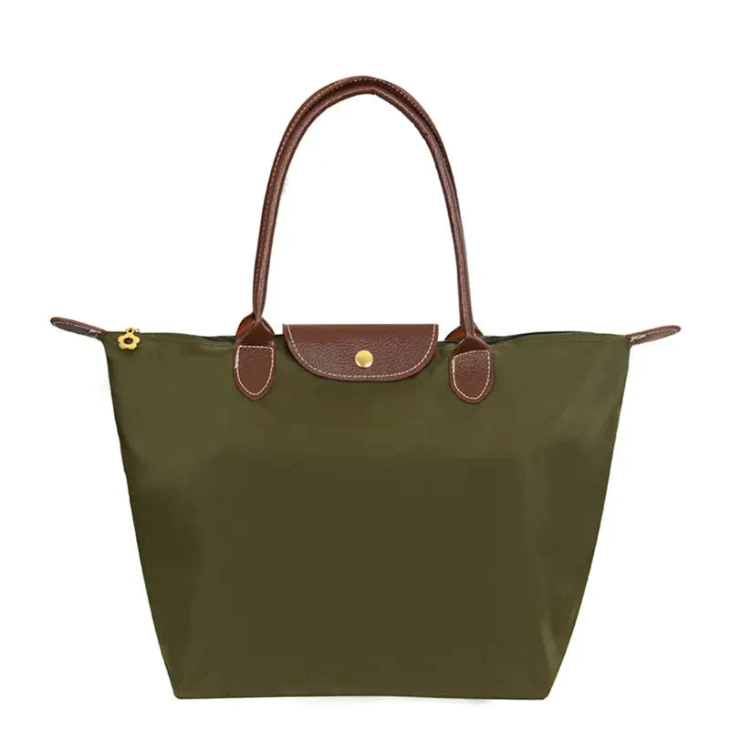 Grüne Damenhandtasche aus Nylon mit braunen Ledergriffen und Reißverschluss.