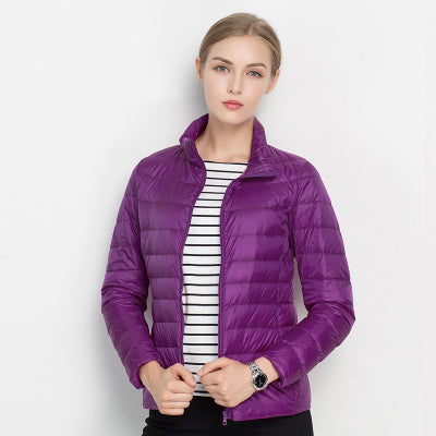 Frau in lila Daunenjacke, gestreiftes Shirt, modische Winterbekleidung, Outdoor-Jacke.