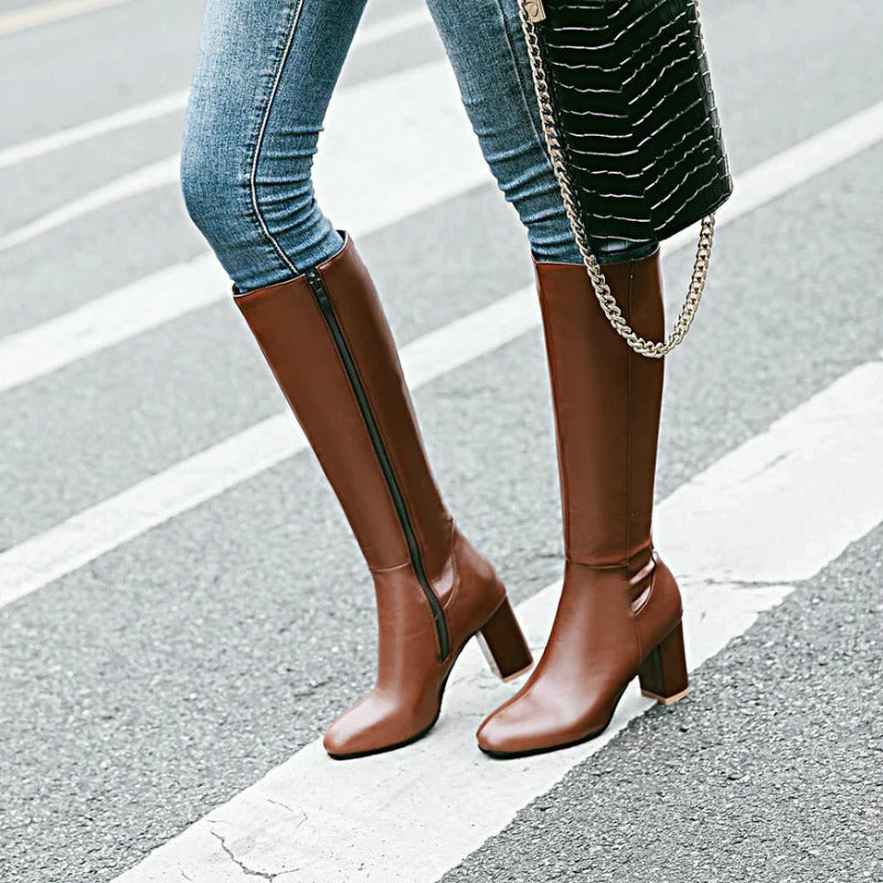 Braune Damenstiefel mit Absatz, Reißverschluss, aus Leder, modisch, elegant, auf Straße.