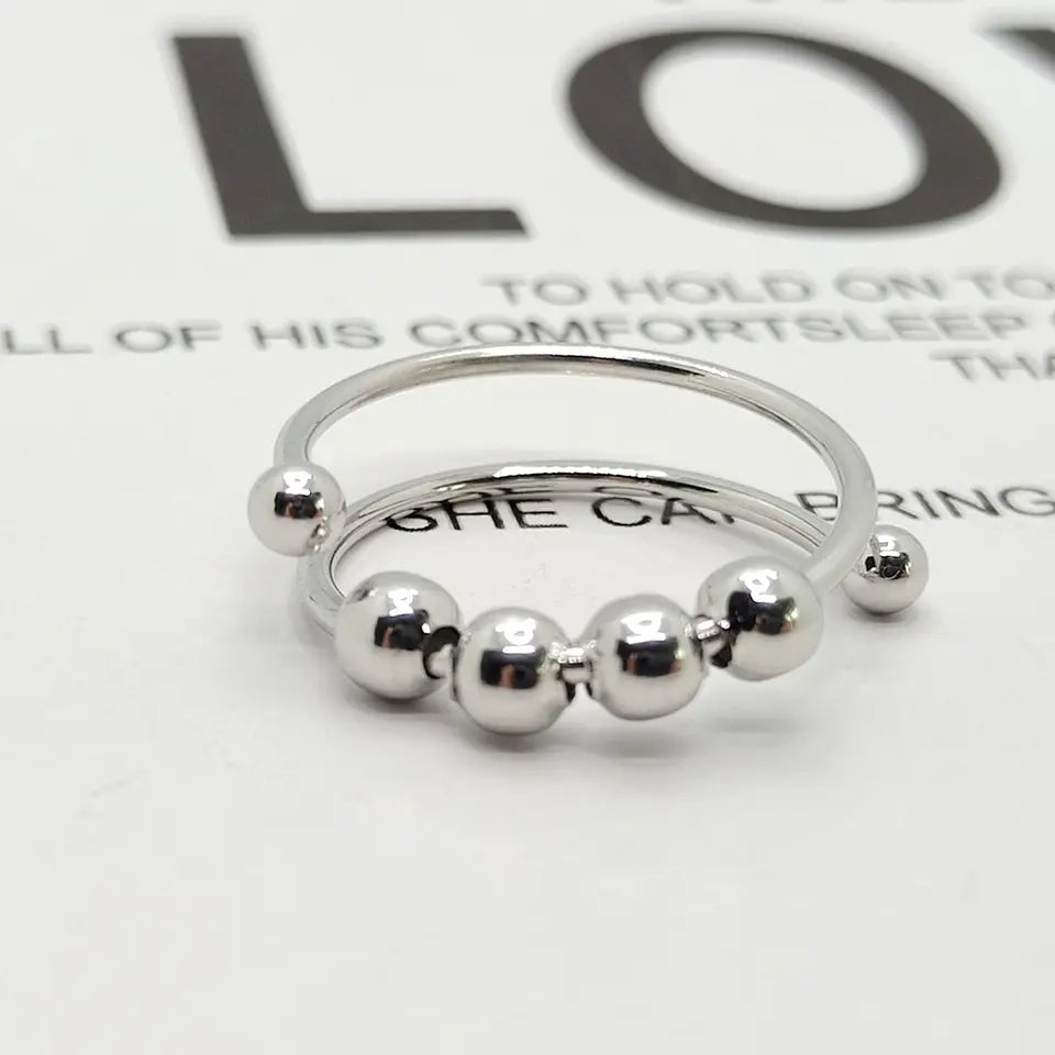 "Drehbarer Anti-Stress-Ring aus Edelstahl, erhältlich in Gold, Roségold und Silber, fördert innere Ruhe und Konzentration."
