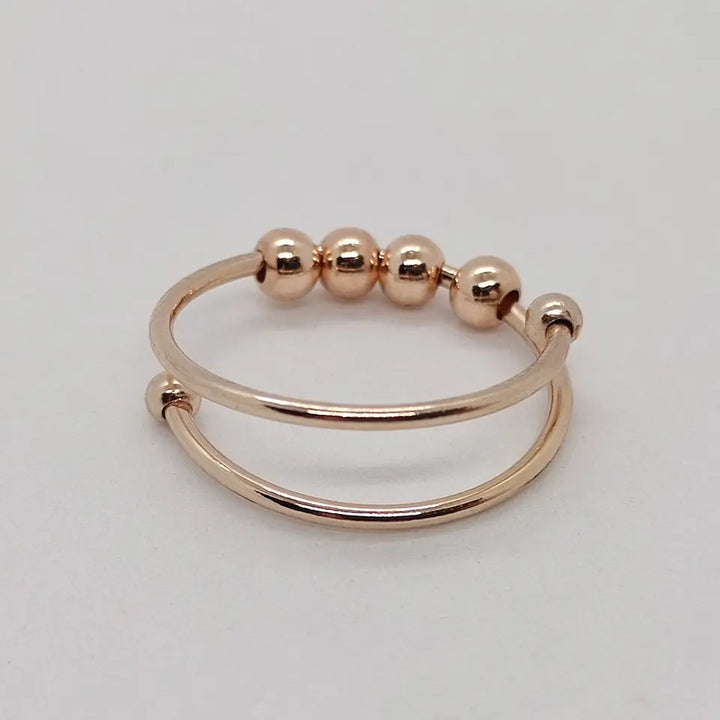 "Drehbarer Anti-Stress-Ring aus Edelstahl, erhältlich in Gold, Roségold und Silber, fördert innere Ruhe und Konzentration."