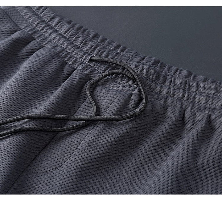 Dunkelgraue Sportshorts aus atmungsaktivem Mesh mit elastischem Bund und Kordelzug.