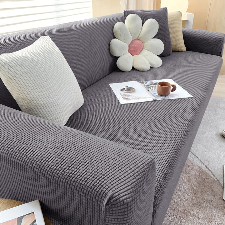 "Elastischer Sofabezug in Beige auf einem Sofa, stilvoller Schutz, passt perfekt durch Flexibilität, für Wohnzimmereinrichtun