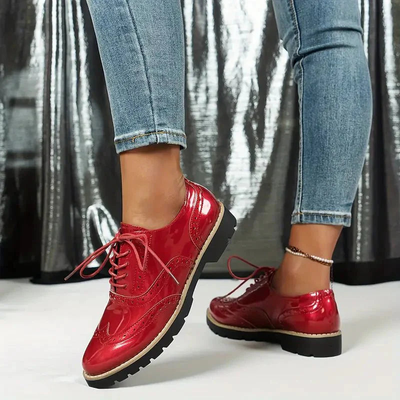 Elegante Damen-Lederpumps in glänzendem Lackleder mit Brogue-Details, vielseitig und komfortabel für jeden Anlass.